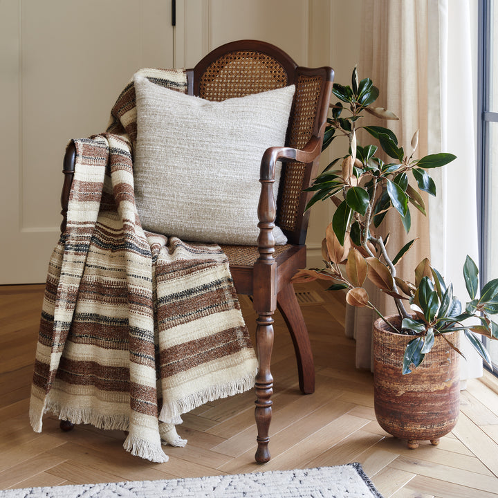 Antique chair styled with a striped Belgian linen blanket and a cream pillow