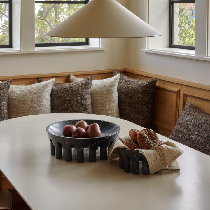 black marble pomona bowls holding apples and bagels in a breakfast nook.