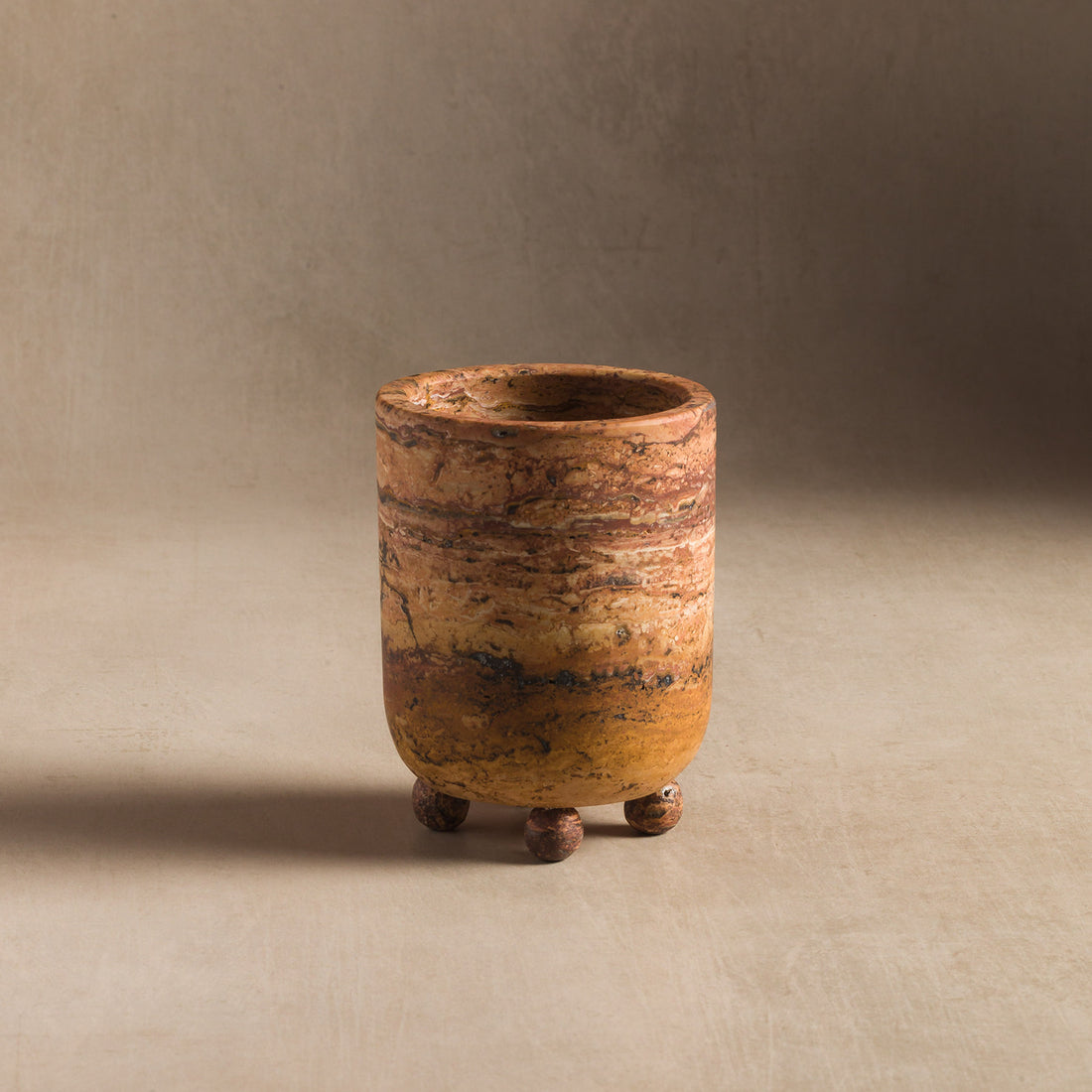Small vessel made of rust travertine for home decor
