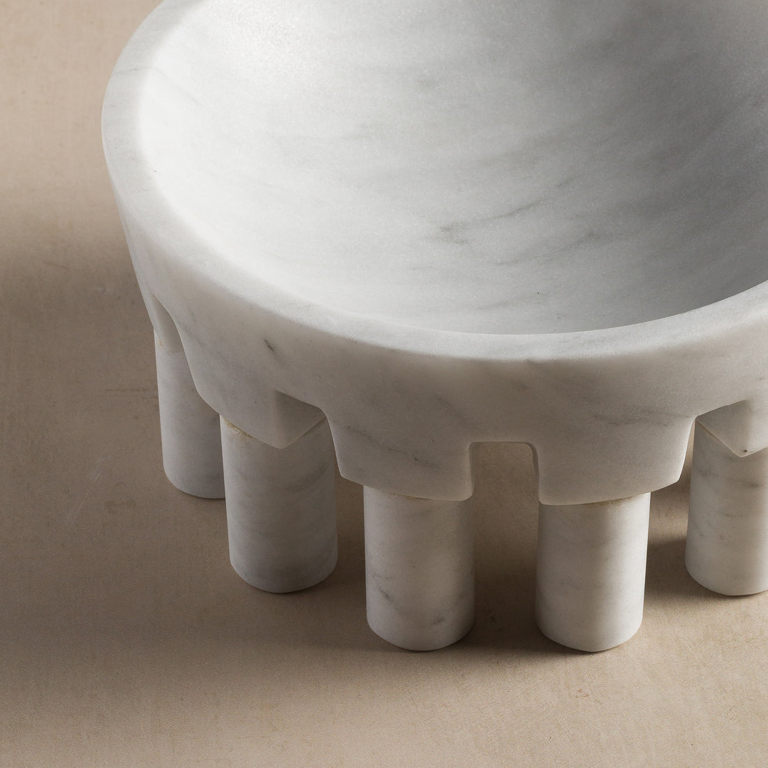 Details of round curves on white marble stone bowl with feet