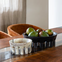 decorative stone bowls holding mangos on a dining table