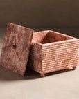 Pink marble square box with lid and ribbing details.