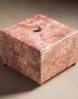 Pink marble square box with lid and ribbing details.