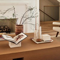 Stone decor and accessories displayed on a coffee table made of light wood.